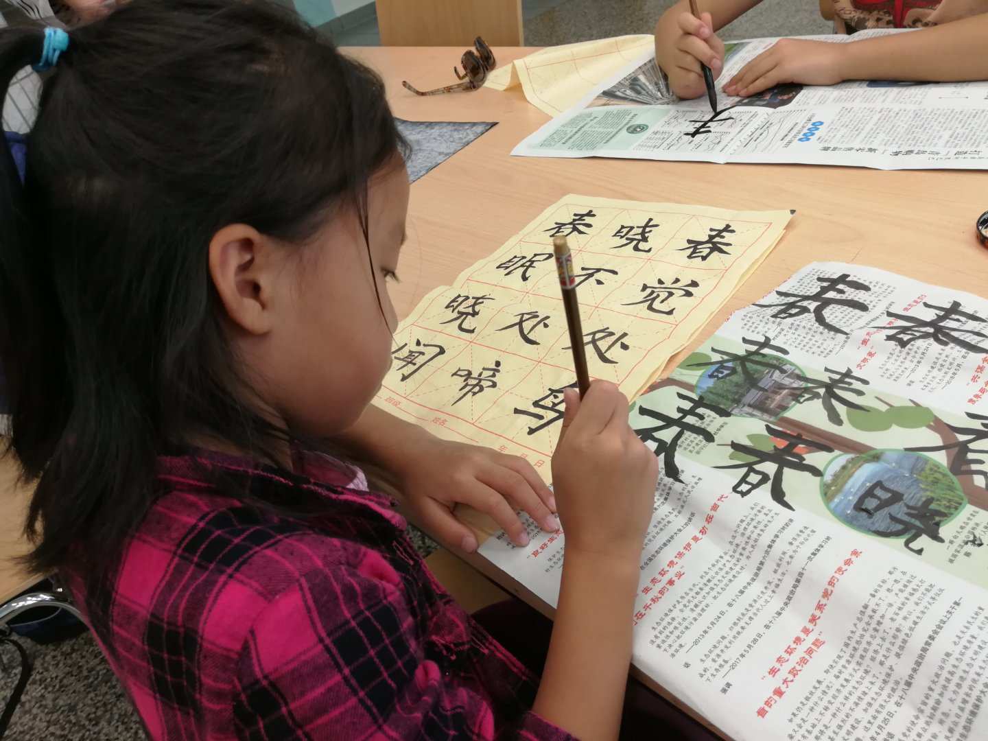 Kind übt chinesische Kalligraphie mit einem Pinsel.